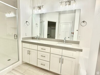 Full bath with a shower stall, double vanity, and a bath