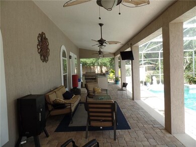 Large shaded lanai with outdoor grilling area.