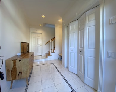 Beyond folding doors in the nicely sized entry foyer is the first bedroom.