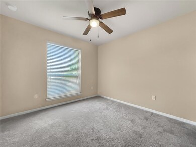 Carpeted empty room featuring ceiling fan and a s