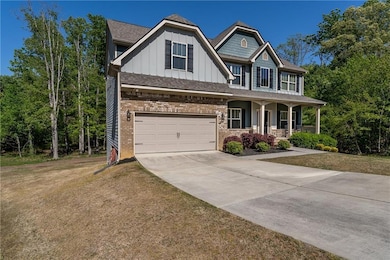Craftsman-style house featuring board and batten siding, a porch, a front lawn, driveway, and a garage