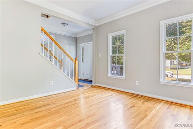 Foyer entrance featuring a healthy amount of sunlight, ornamental molding, and hardwood / wood-style floors