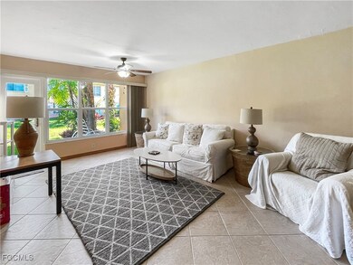 Living room with light tile patterned floors and a ceiling fan