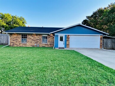 Single story home featuring a front yard and a gar