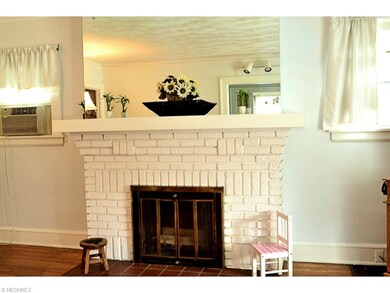 Original brick and tile floor of this wood burning Fireplace, surrounded on either end by two lovely windows!