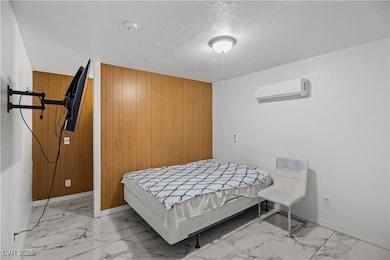 Bedroom with baseboards, a wall mounted air condit