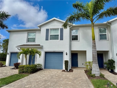 View of front of property featuring stucco siding, an attached garage, and decorative driveway