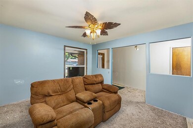 Living room featuring ceiling fan and carpet floor