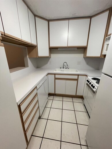 Kitchen with stove, dishwasher, white cabinets, l