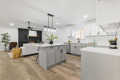 Kitchen with dishwasher, a brick fireplace, decora