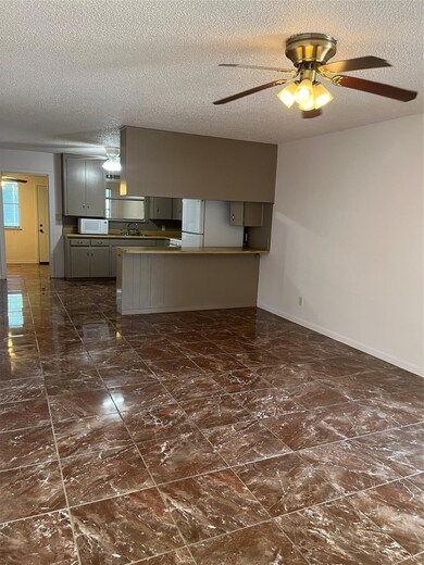 Kitchen featuring a ceiling fan, baseboards, a te