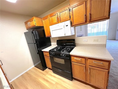 Kitchen featuring black appliances, brown cabinets