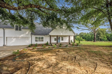 View of front of house featuring roof with shingles, driveway, and a front yard