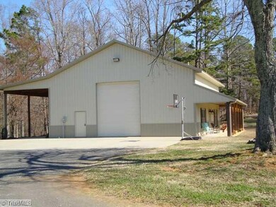 Exterior Front. Workshop side view with 14  overhead door, personnel door, 13  covered overhang with RV hookup, Has 8  front porch and large parking pad.