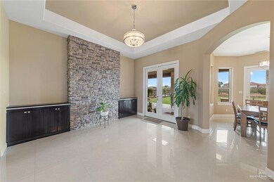 Tiled living room with a chandelier, french doors, and a raised ceiling