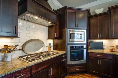The rich tones of the cabinetry complement the warm amber and chocolate hues in the granite countertops. 