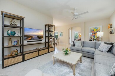 Living area with arched walkways, light tile patterned floors, and ceiling fan