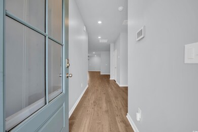 Hallway with recessed lighting, visible vents, bas