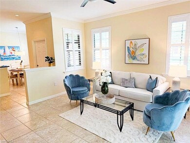 Living room with ceiling fan, crown molding, and p