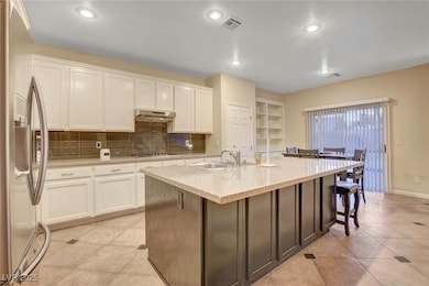 Kitchen with stainless steel fridge, a sink, under