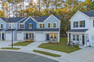 Traditional home with driveway, a front yard, a shingled roof, and an attached garage