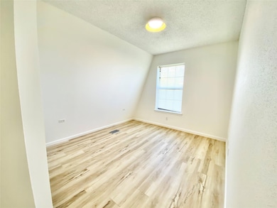 Empty room with baseboards, a textured ceiling, w