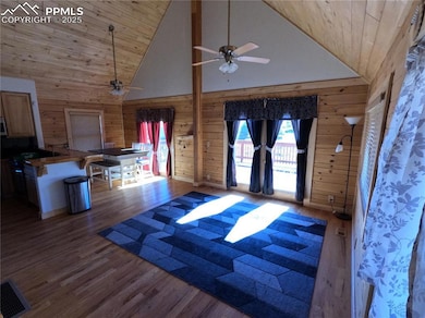 Foyer entrance with high vaulted ceiling, wood walls, dark wood finished floors, and wood ceiling