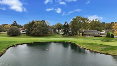 View of property's community featuring a water view, view of golf course, and a lawn