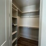 Walk in closet with dark hardwood / wood-style flo