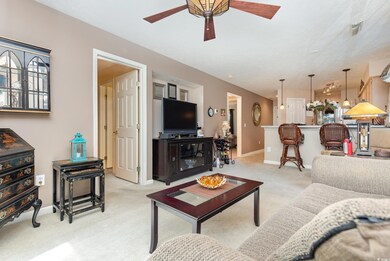 Living room featuring light carpet and ceiling fan