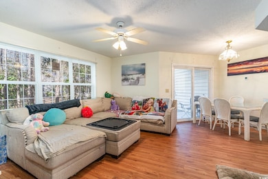 Living room with ceiling fan with notable chandeli