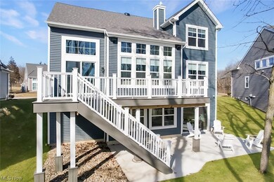 Rear view of house with a wooden deck, a lawn, and a patio