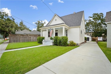 View of front facade with covered porch, roof with shingles, and driveway