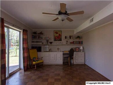 Den/Family Room has wood floors, ceiling fan, custom built-ins and sliding glass doors to patio.