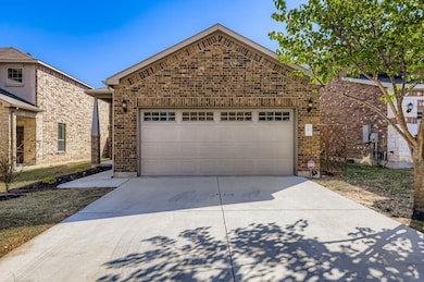 View of front of house featuring brick siding, concrete driveway, and an attached garage