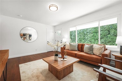 Living area with dark wood flooring and baseboards