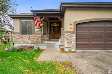 Entrance to property featuring stone siding, stucco siding, a garage, and a porch