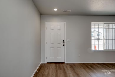 Entryway with wood finished floors and recessed lighting