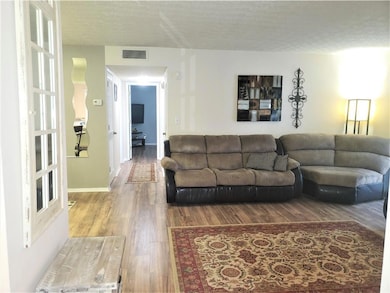 Living area featuring wood finished floors and a textured ceiling