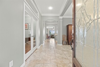 Bright entryway with tile flooring, crown molding,