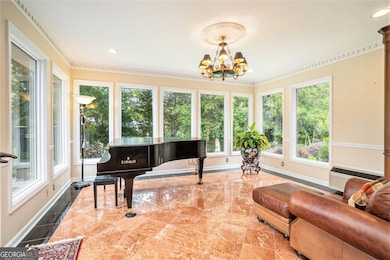 Stunning Sunroom with Floor-to-Ceiling Windows and Sophisticated Stone Tile Flooring offers a Serene Spot to Unwind, Entertain, or Soak in the Views of your Private Backyard Oasis.