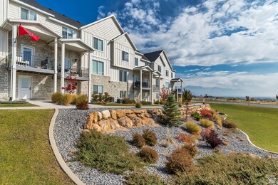 View of home's exterior with stone siding, board and batten siding, a balcony, a lawn, and a residential view