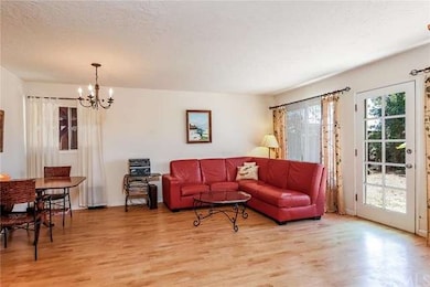 The bright, airy living room has nice wood floorin