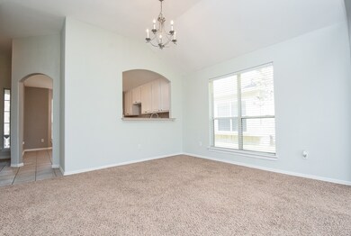 A grand high ceiling/chandelier marks this spacious, naturally lit formal dining area.