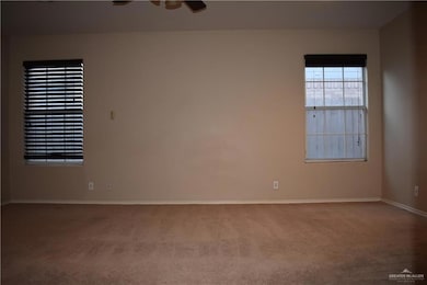 Empty room featuring light colored carpet and a ceiling fan