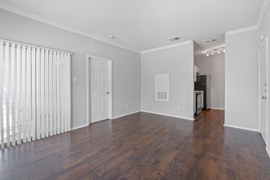 Unfurnished living room with dark wood-style floo