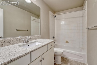 Bathroom featuring a vanity, shower/washtub combination, hardwood floors, and a textured wall finish.