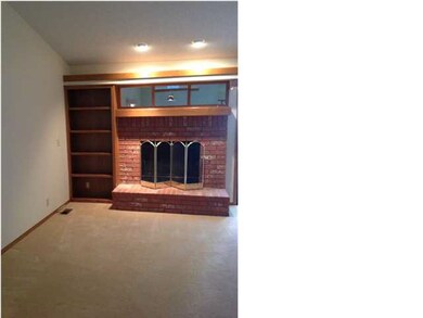 Living room with wood burning fireplace and vaulte