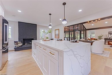 Kitchen with a brick fireplace, a center island, w