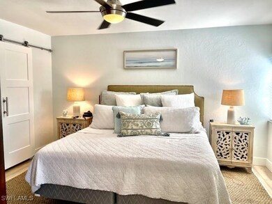 Bedroom with a ceiling fan and a barn door